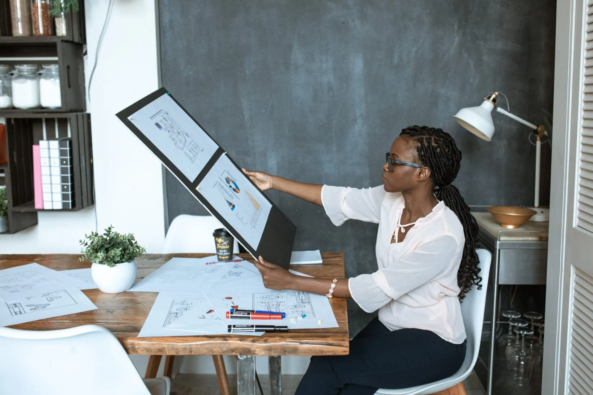 Interior designer reviewing floor plans and drawings at her desk