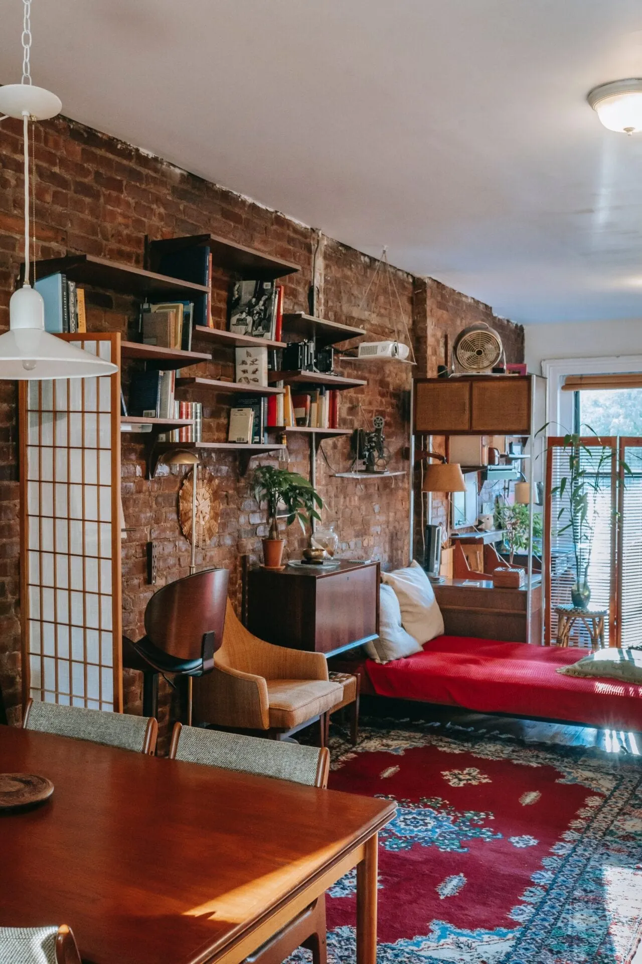 Eclectic loft with exposed brick, timber shelving and shoji screens