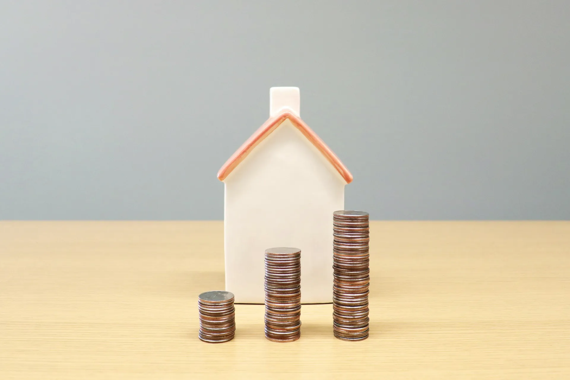 Small model house beside stacks of coins, representing a home renovation loan