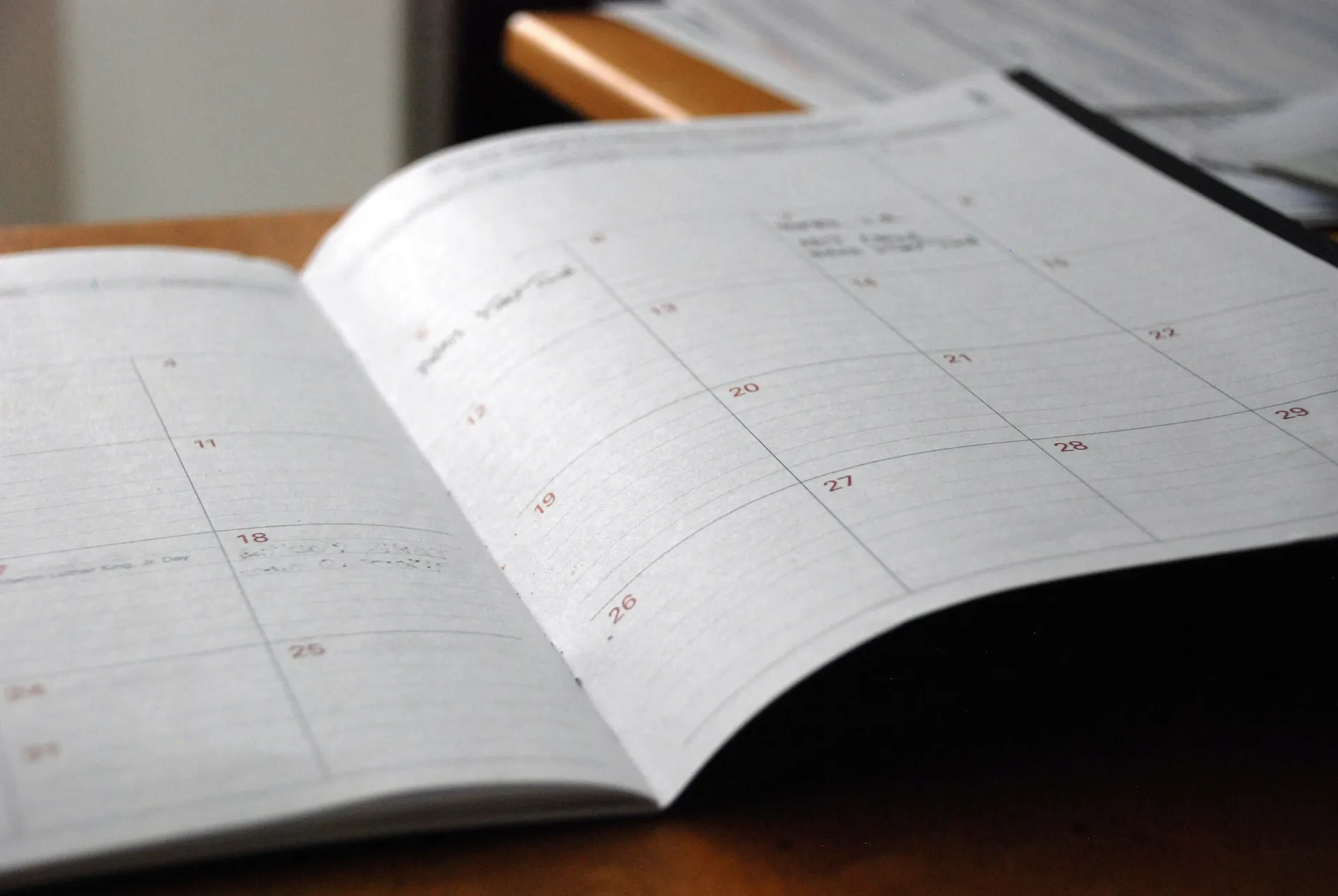 Open monthly planner on a wooden desk for planning a renovation schedule
