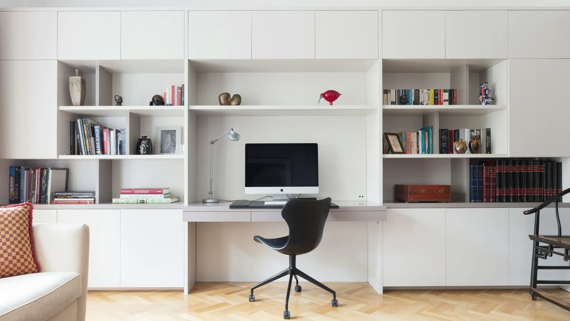 Wall-to-wall white built-in desk with open shelving above