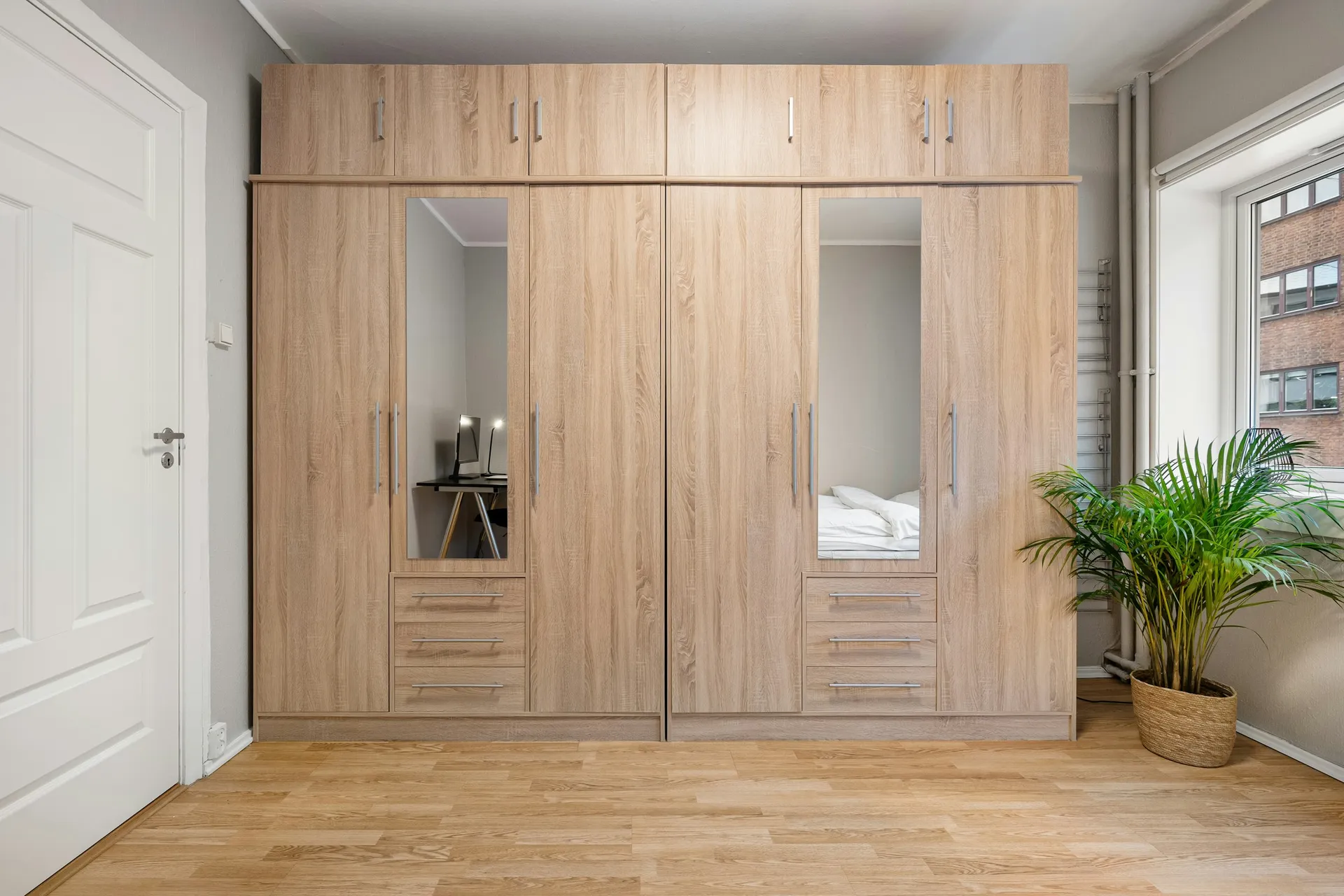 Light wood wardrobe with a mirrored centre panel and drawers