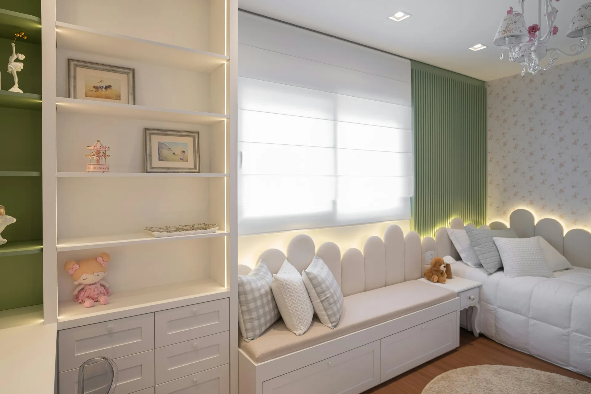 Cushioned window seat with white built-in shelves and drawers in a child's room