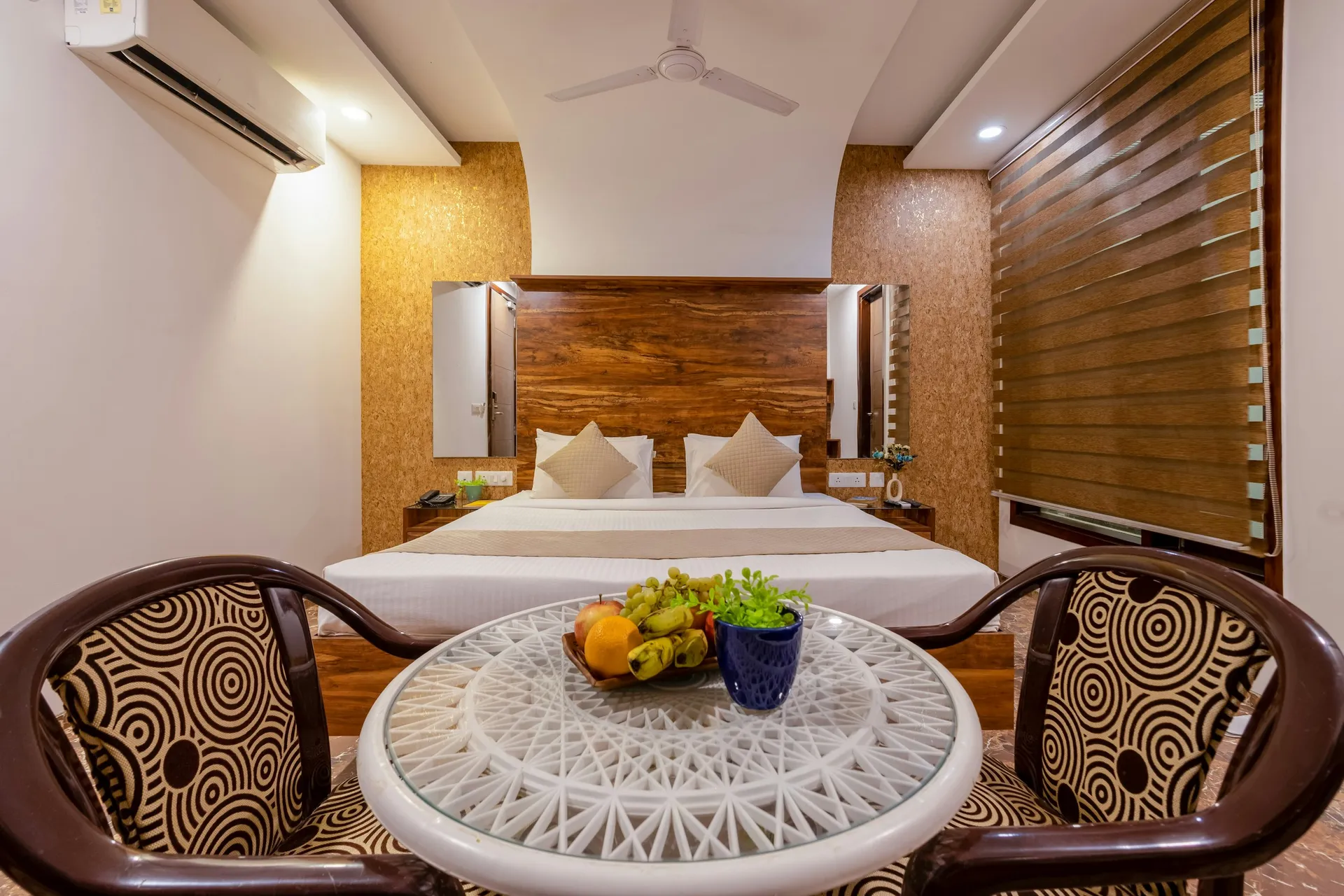 Wall-mounted split air-conditioner above a bed in a calm, modern bedroom