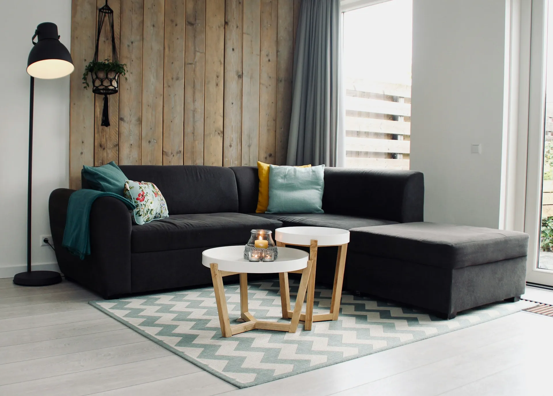 Light grey fabric sofa with cushions in a bright, airy living room