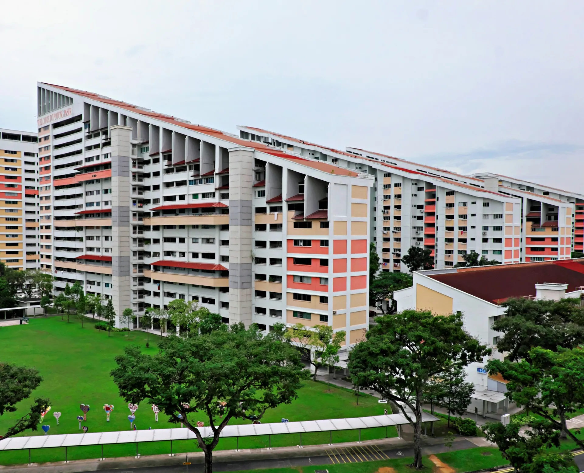 HDB blocks in Singapore seen from above, with trees and a grass field in front