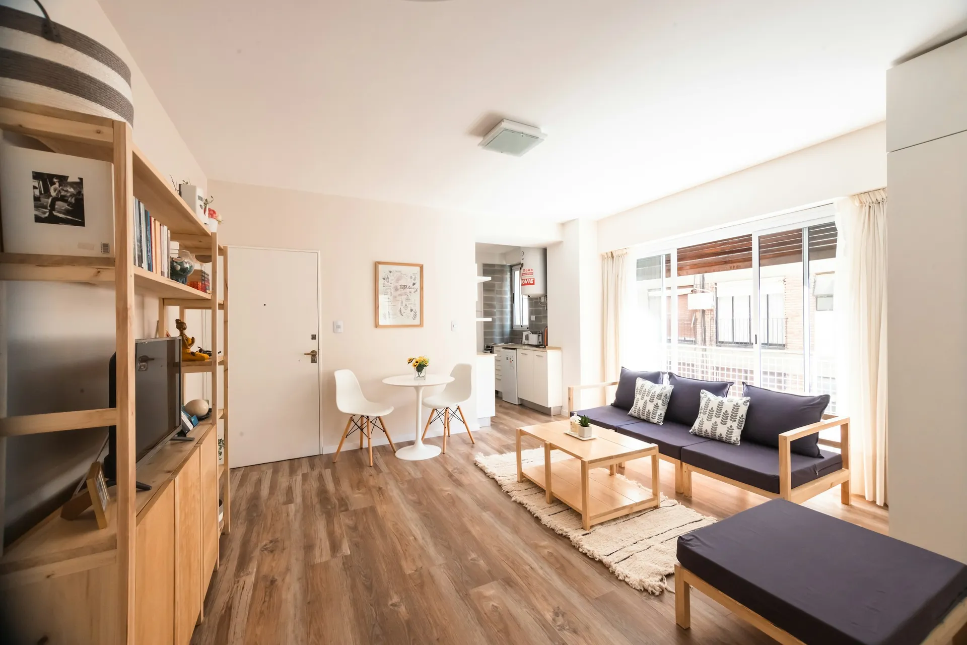 Bright living room with light oak-look plank flooring, a low sofa and natural daylight