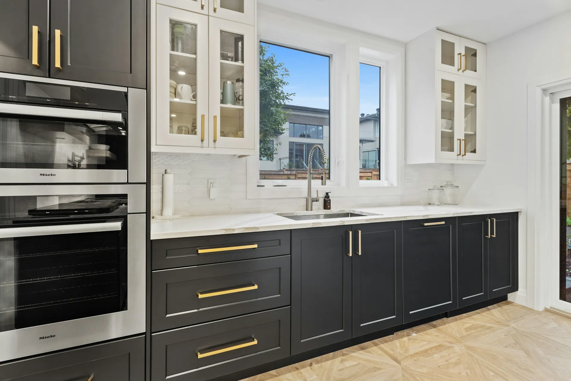 Modern kitchen with flat laminate cabinet doors, a stone-look countertop and a built-in hood