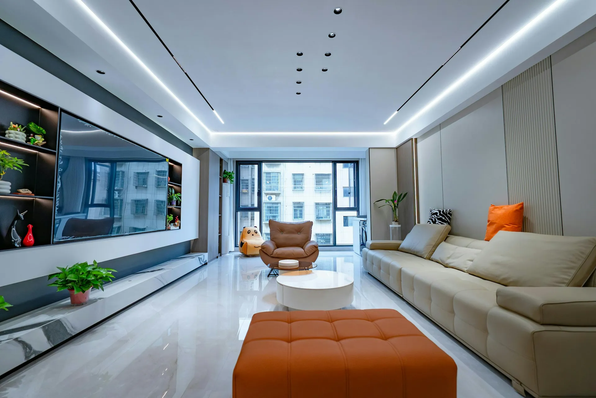 Long living room with linear cove lighting along a white false ceiling