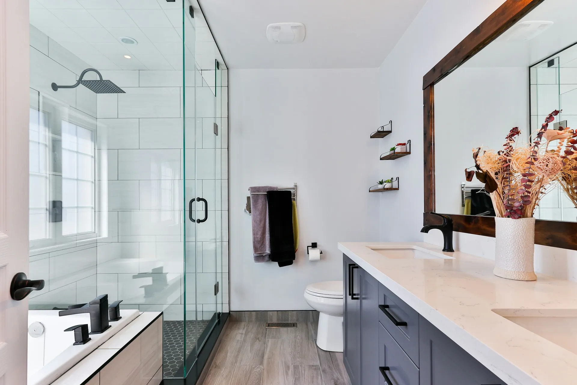 Modern bathroom with a glass-enclosed shower and a long vanity with framed mirror
