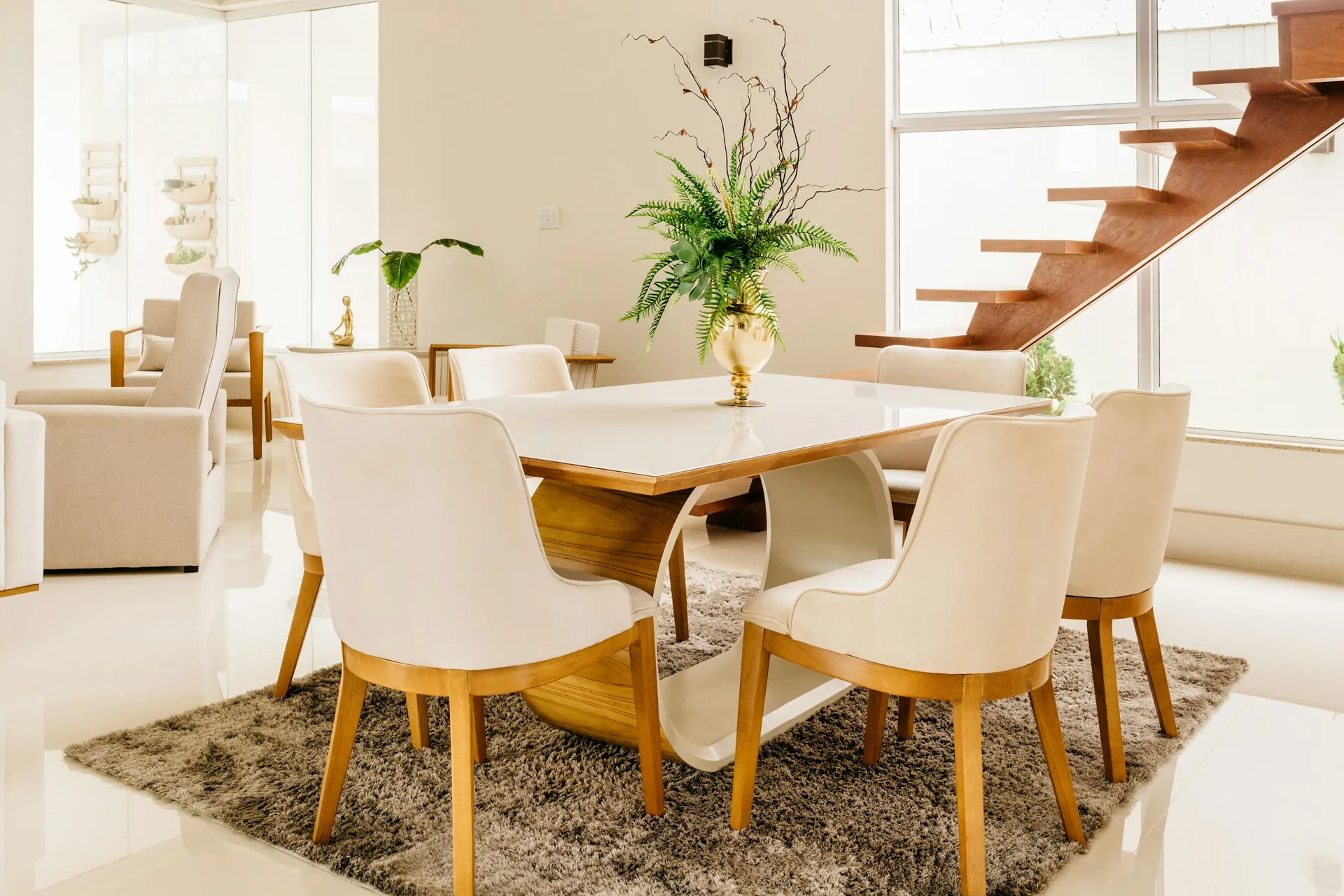 Wooden dining table with chairs under a pendant light in a bright open-plan home