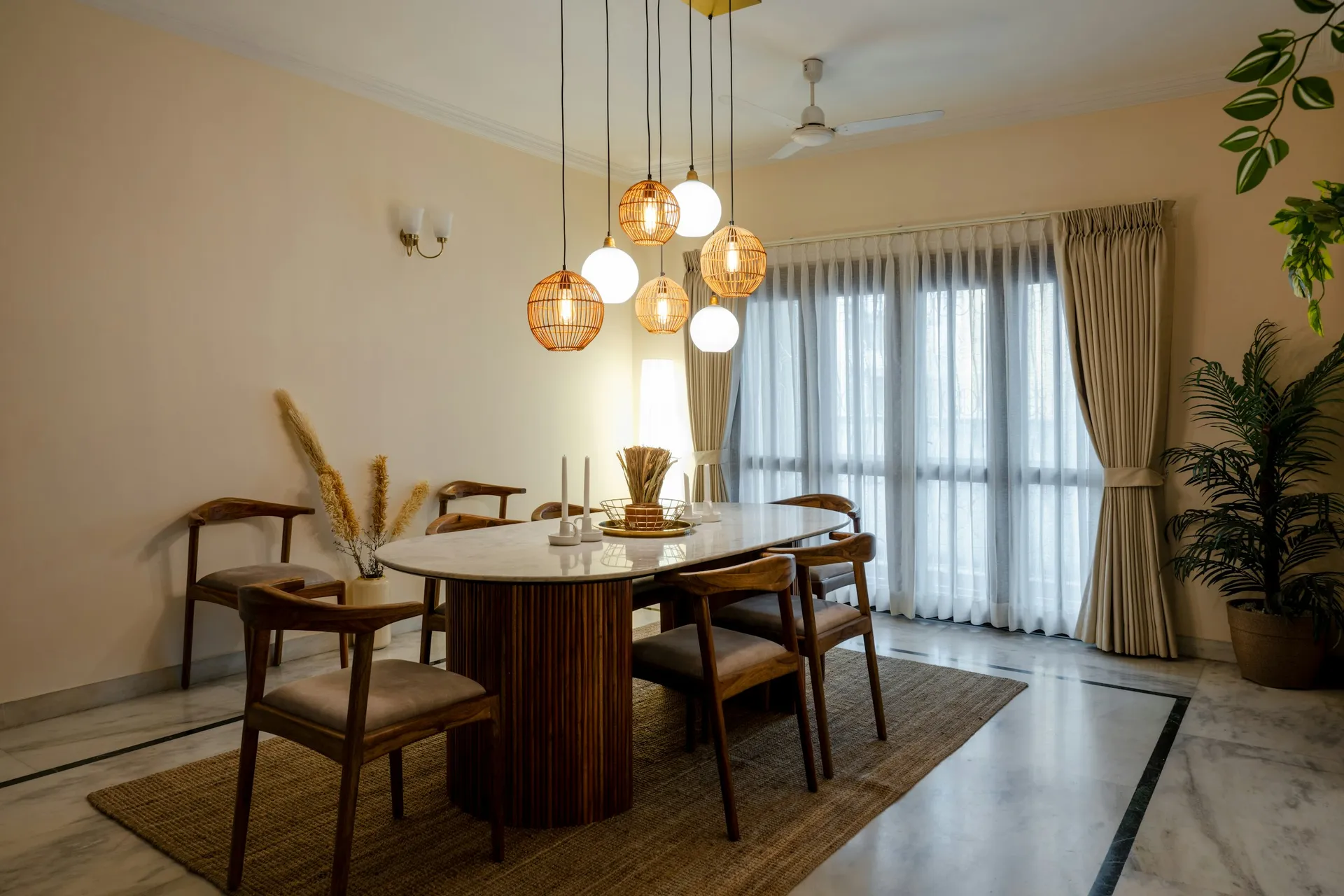 Cluster of glass pendant lights above an oval wooden dining table