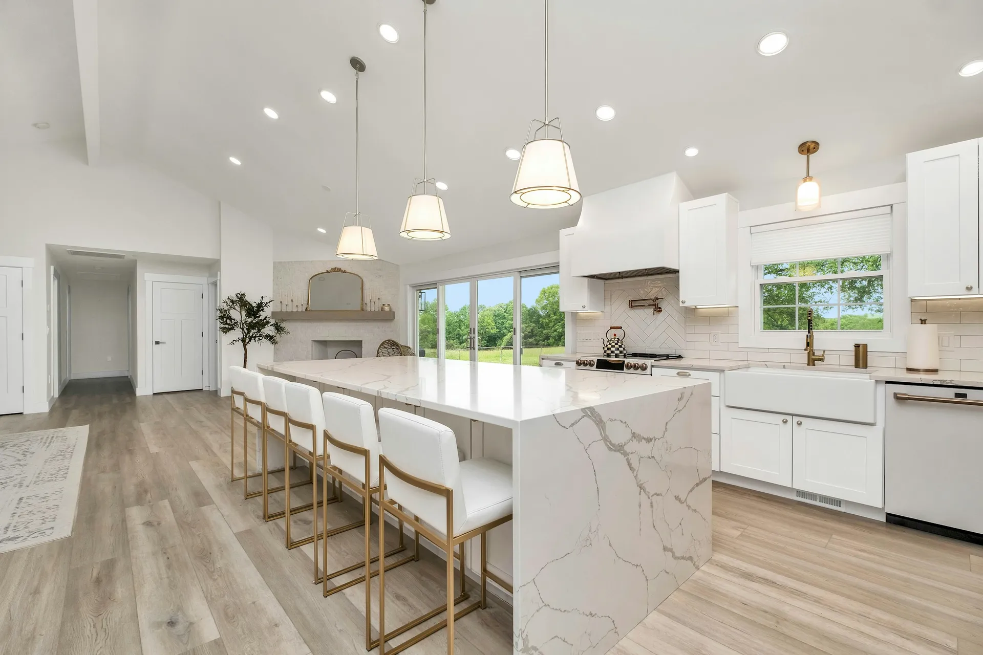 Open-plan kitchen with a stone-topped island and bar stools facing the living area