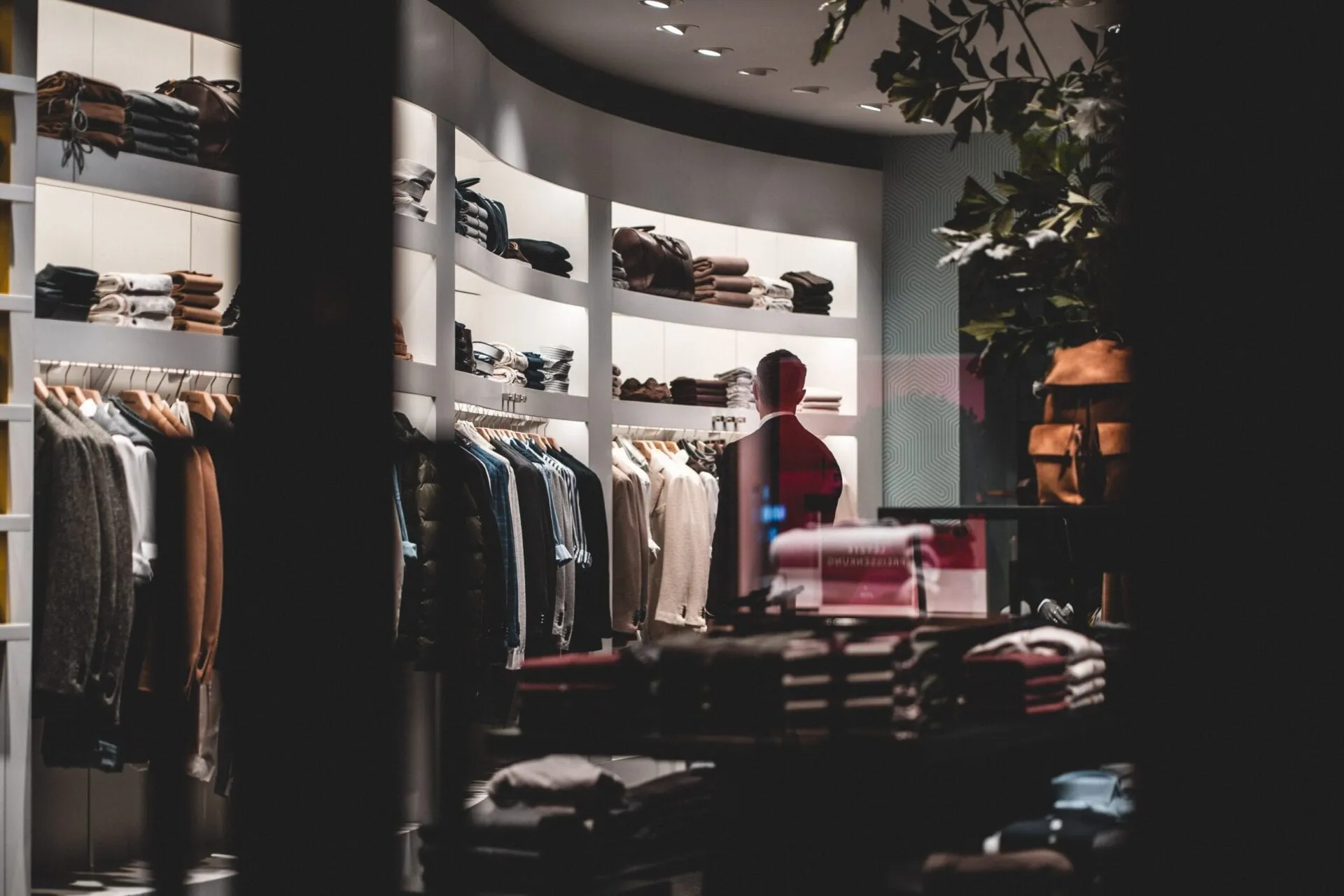 Walk-in wardrobe with dark open shelving and hanging clothes